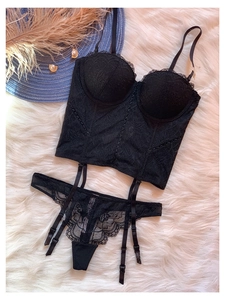 Détail de l'ensemble de lingerie en dentelle noire avec bustier et string sur fourrure
