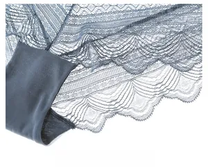 Detailed macro view of delicate blue French lace and sheer mesh fabric on bra cup