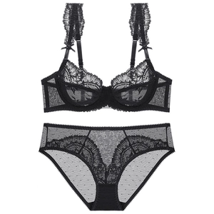 Flat lay of black lace lingerie set with sheer polka dot mesh and floral embroidery