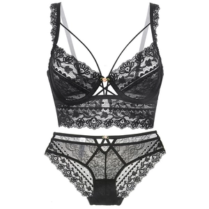 Détail d'un ensemble de lingerie en dentelle noire avec petites roses roses et dos croisé