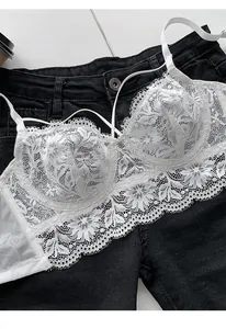 Macro shot of delicate white floral eyelash lace bra with vintage French embroidery texture