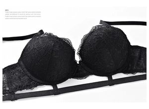 Detail of floral lace texture and decorative elastic straps on a black push-up bra