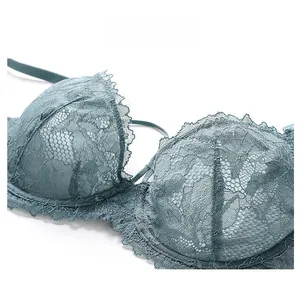 Détail macro de la broderie en dentelle bleu canard et tulle sur le soutien-gorge