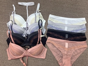 Detailed flat lay of deep V lace lingerie sets in white, grey, black and pink colors
