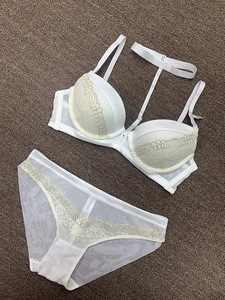 Flat lay of a white lace lingerie set with deep V bra and matching mesh panties