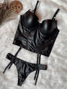 Flat lay of black faux leather corset with garters and thong on white plush fur