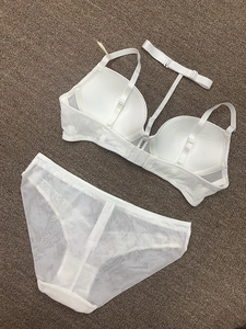 Flat lay of white deep V lace lingerie set with neck strap and sheer mesh panties