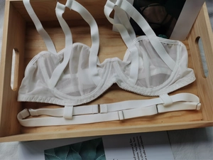 Détail d'un soutien-gorge en maille transparente blanche avec sangles et anneaux en métal