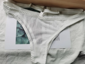 Vue détaillée du string en maille blanche avec bretelles réglables et dentelle