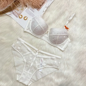 Détail d'un ensemble de lingerie en dentelle blanche avec broderie et bretelles croisées
