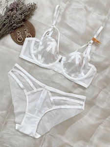 Détails d'un ensemble lingerie en maille blanche avec lanières et dentelle fine