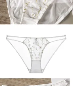 Détail de culotte en résille blanche avec broderie florale et fines lanières latérales