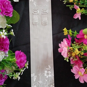 Detailed view of clear elastic bra straps with white hooks on card packaging