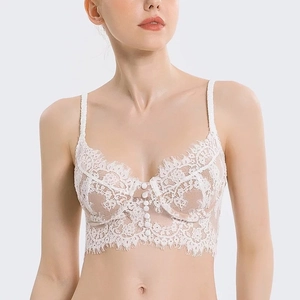 Détail de la bralette blanche en dentelle de cils avec boutons et fines bretelles