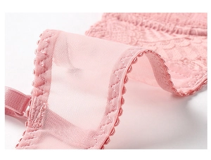Gros plan sur la broderie en dentelle rose avec maille translucide et coutures