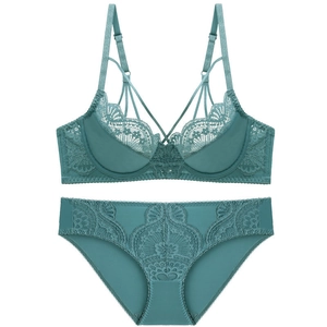 Flat lay of teal lace lingerie set featuring intricate floral embroidery and harness detail