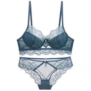 Close-up of teal floral lace lingerie set with pink rose detail and eyelash trim