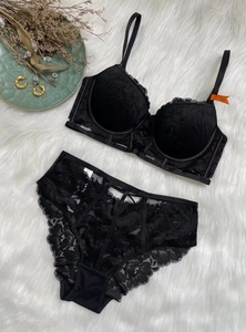 Ensemble de lingerie en dentelle noire avec culotte à lanières sur tapis blanc moelleux