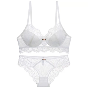 Detail view of white lace lingerie set with delicate floral patterns and pink rose accent