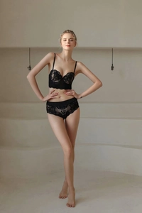 Detail eines eleganten schwarzen Spitzen-Dessous-Sets mit Stickerei und weicher Textur