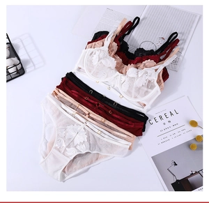 Close-up of floral embroidery detail and gold metal buckles on lace lingerie set
