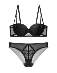Dettaglio ricamo in pizzo sul set reggiseno push-up nero e slip in rete con motivi a onde