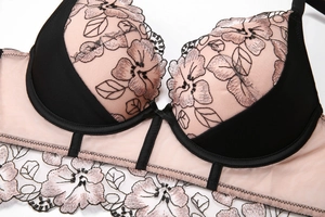 Détails de broderies florales et dentelle sur un soutien-gorge noir à armatures