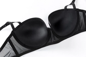 Dettaglio del reggiseno in pizzo nero a 1/2 coppa con coppe interne lisce e ali in rete