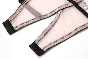 Détail du soutien-gorge en dentelle rose avec bretelles noires et broderies florales
