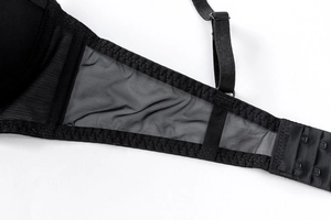 Dettaglio reggiseno in pizzo nero con tessuto a rete traspirante e chiusura a tre file