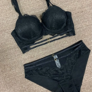 Détail de l'ensemble lingerie en dentelle noire avec anneaux dorés et fines lanières