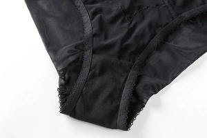 Dettaglio ravvicinato di slip in pizzo nero con tessuto a rete traspirante e cuciture
