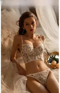 Vue détaillée de la broderie florale blanche et dentelle délicate sur ce bustier français