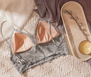 Detail of grey lace floral lingerie featuring adjustable straps and delicate mesh texture
