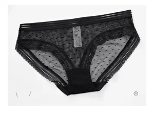 Détail de culotte en dentelle noire avec triple taille élastique et mesh à pois fins