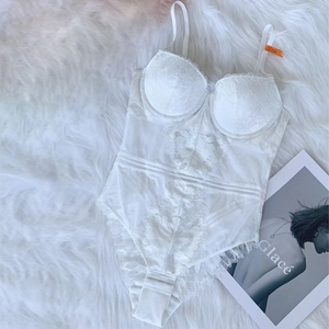 Detailed macro view of white lace bodysuit with sheer mesh panels and 75B size tag