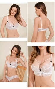 Detail of white lace bra set with black bows and sheer mesh fabric textures