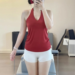 Mirror selfie showing red V-neck yoga top and white high-waist drawstring shorts set