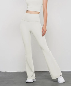 Detalle de los pantalones de yoga acampanados de cintura alta en crema elástica