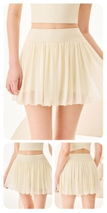 Détail de jupe de tennis plissée crème avec taille haute et tissu en maille