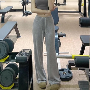 Détail du pantalon de yoga gris à taille haute avec cordon de serrage dans une salle de gym