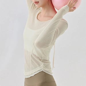 Detail of white yoga long sleeve top with back tie-up design and breathable fabric