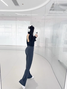 Detail showing high-waisted flared yoga pants and open back long sleeve top set in black