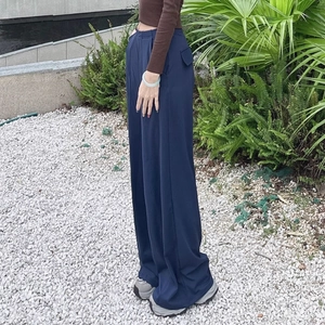Detailansicht der dunkelblauen Yoga-Hose mit hoher Taille, weitem Bein und seitlichen Taschen