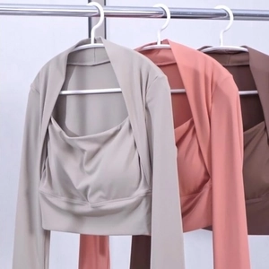 Drie kleuren nauwsluitende yoga tops met lange mouwen en pads aan kledinghangers