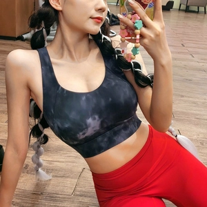 High-impact sports bra with marble pattern and red high-waist leggings for gym fitness