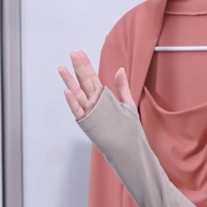 Detail van roze yoga-top met lange mouwen, duimgaten en stijlvolle grijze contrastmanchetten