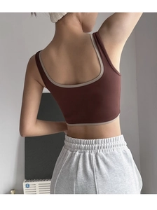 Detail view of the deep coffee yoga vest with cream piping and U-shaped back design