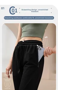 Détail de la taille haute à cordon et poche zippée sur un pantalon de sport noir ajusté