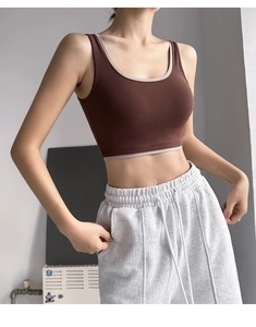 Detail of high-support color block yoga bra and grey drawstring sweatpants on a model